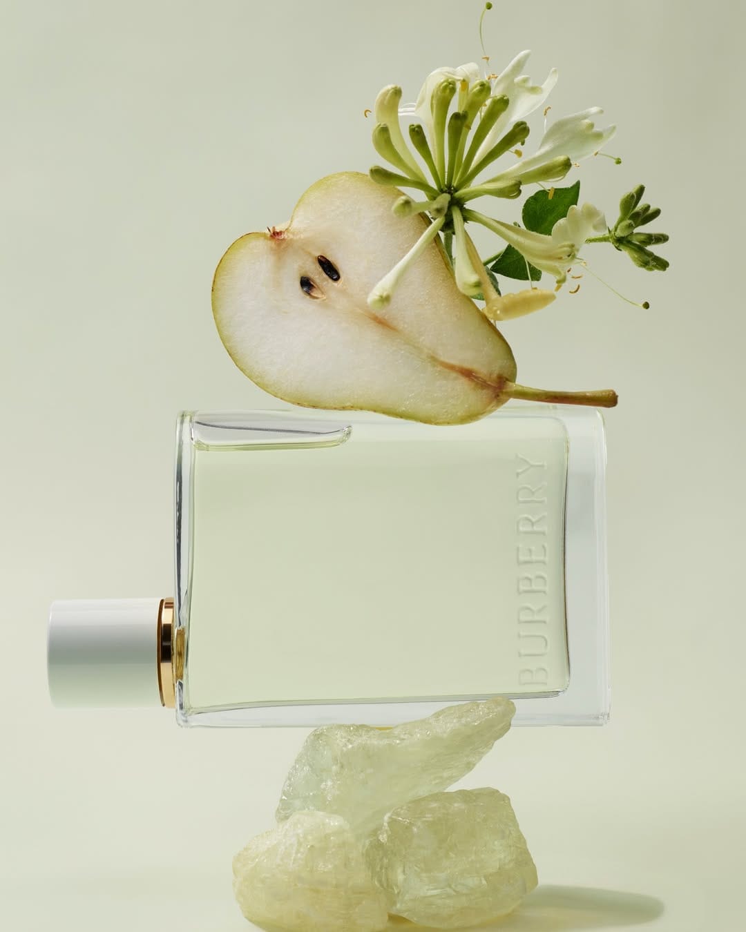 Burberry Her fragrance product photo: clear glass, white cap and pale pear green, glass, soft light