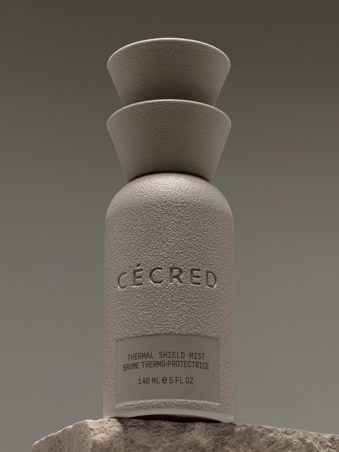 Cécred haircare product photo: stone grey and greige, stone, soft light