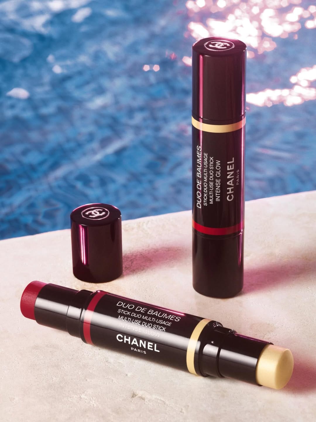 Chanel Duo de Baumes product photo: gloss black, burgundy, coral pink and gold band, plastic, dramatic light