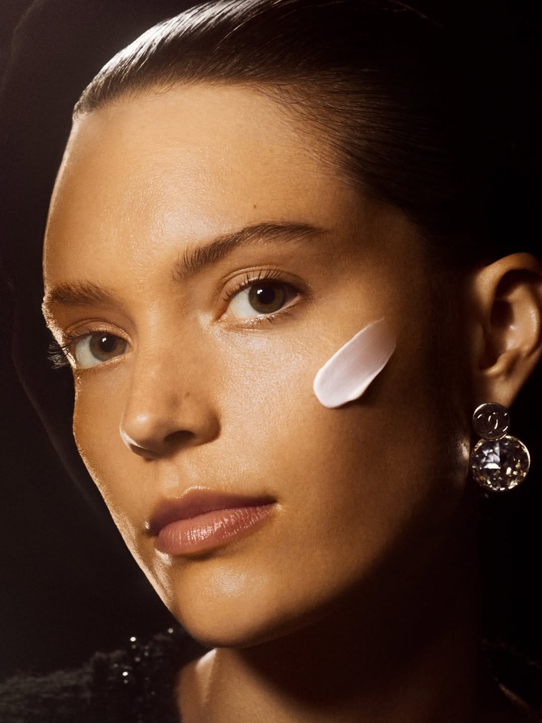 Chanel Sublimage product photo: champagne gold, black cap and cream white, glass, dramatic light, image 2 of 2