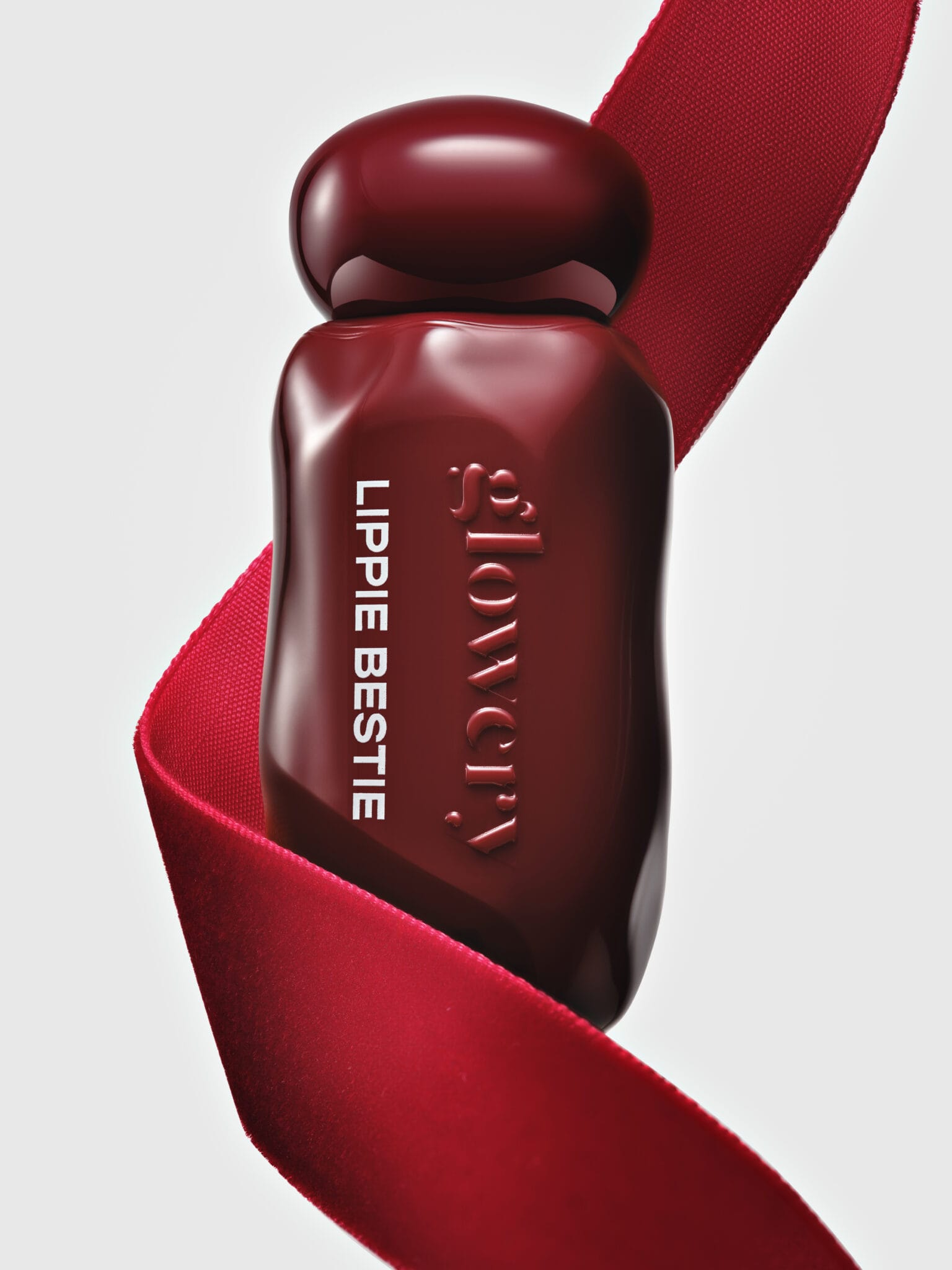 Glowery's mirror-shine lip oils product photo: cherry red and oxblood, glass, studio light