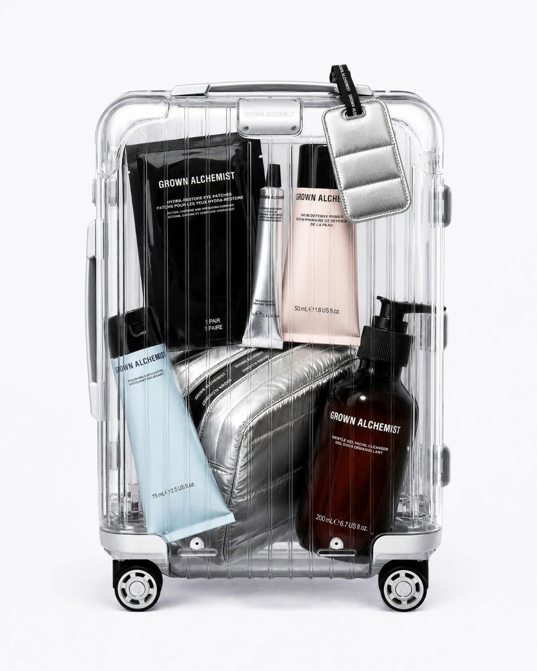 Grown Alchemist travel skincare product photo: matte black, metallic silver, blush pink and pale blue, plastic, soft light