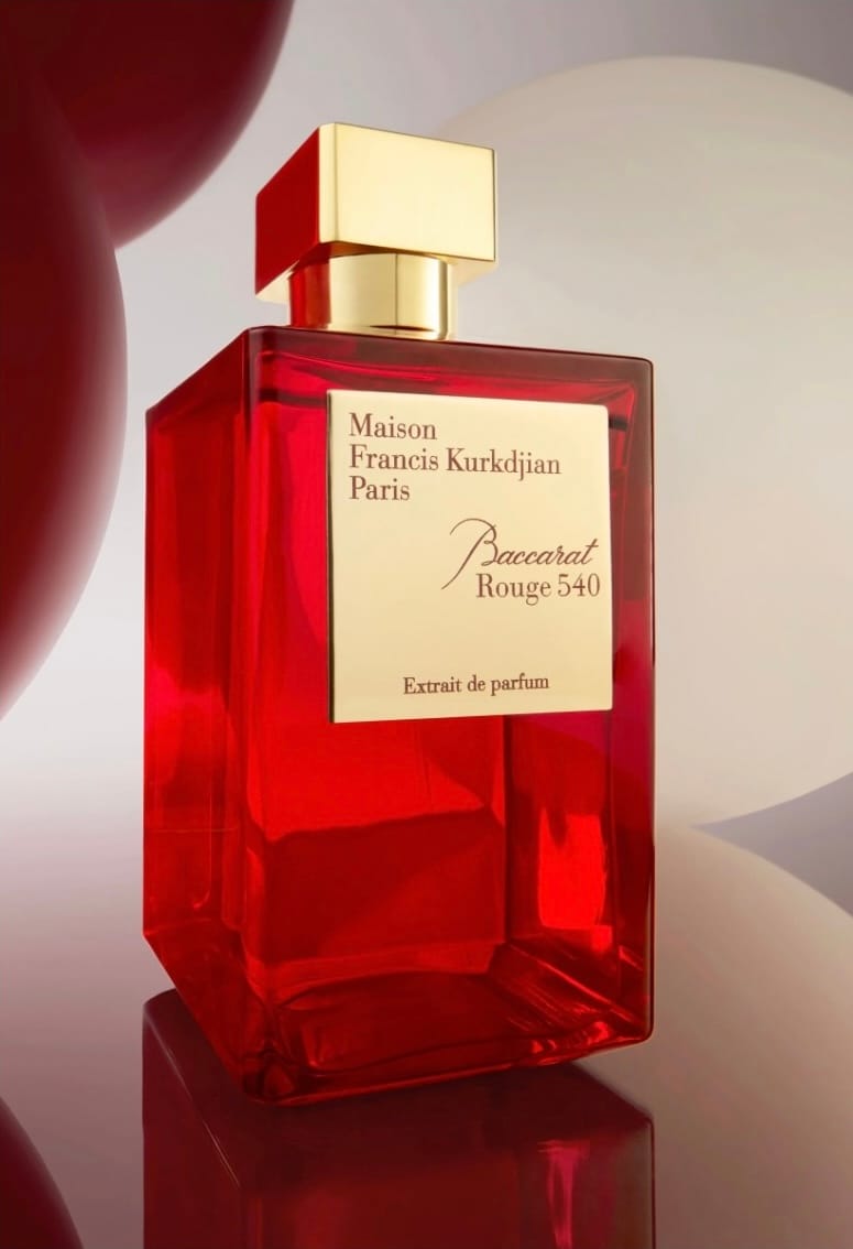 Maison Francis Kurkdjian product photo: crimson red and gold cap, glass, soft light