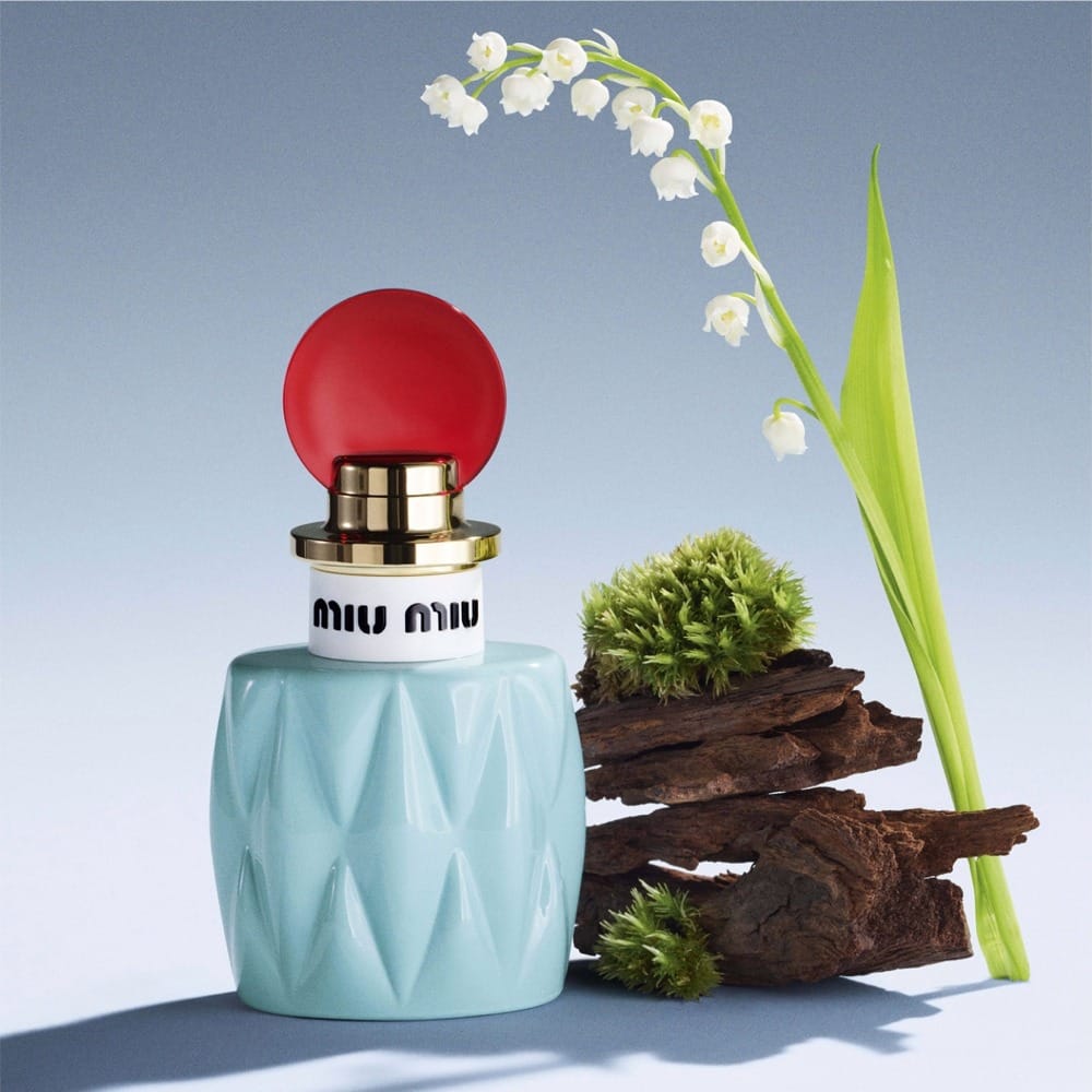 Miu Miu fragrance product photo: powder blue, cherry red, gold collar and white, glass, studio light
