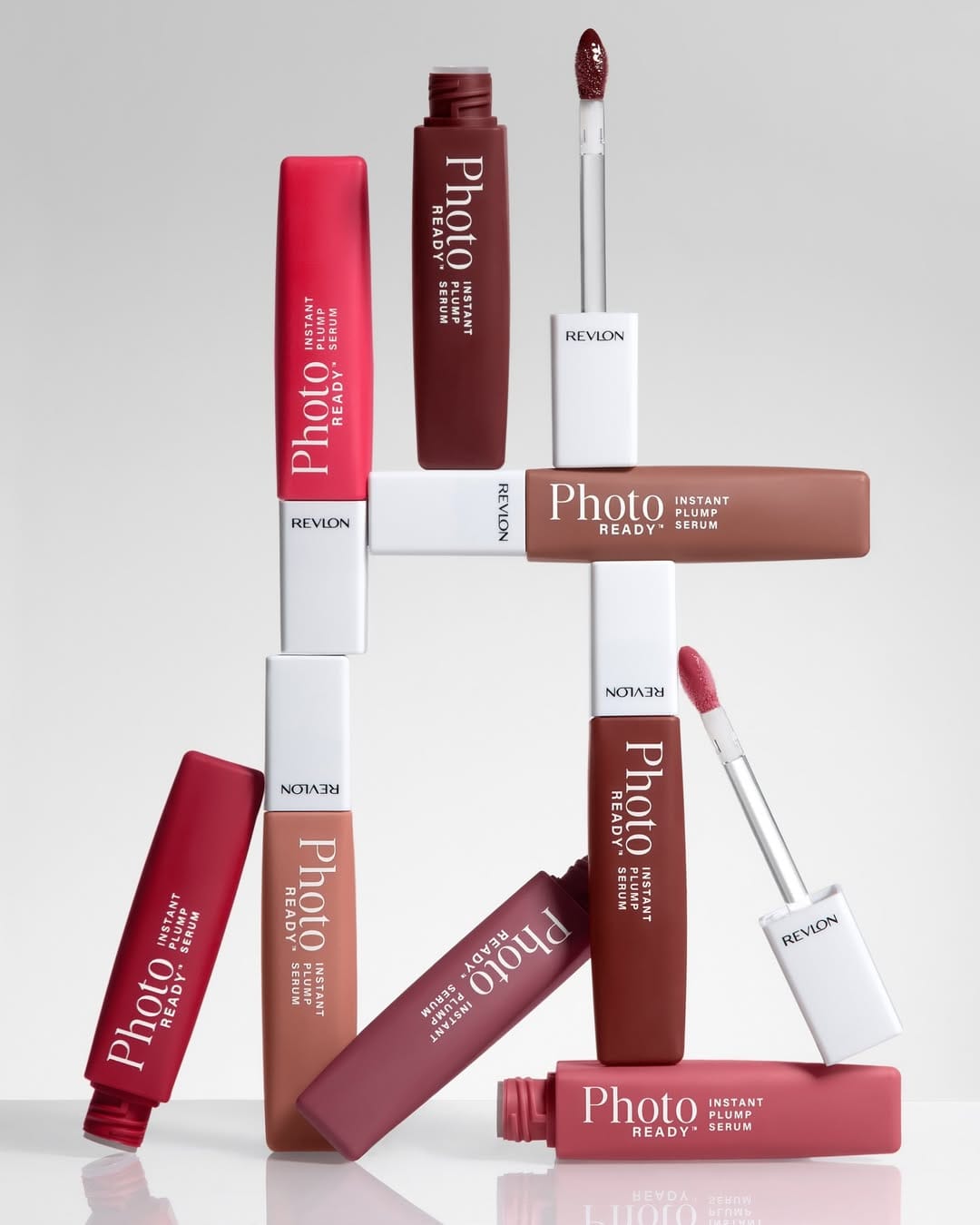 Revlon PhotoReady lip serum product photo: berry red, rose, brown and white cap, glass and plastic, studio light