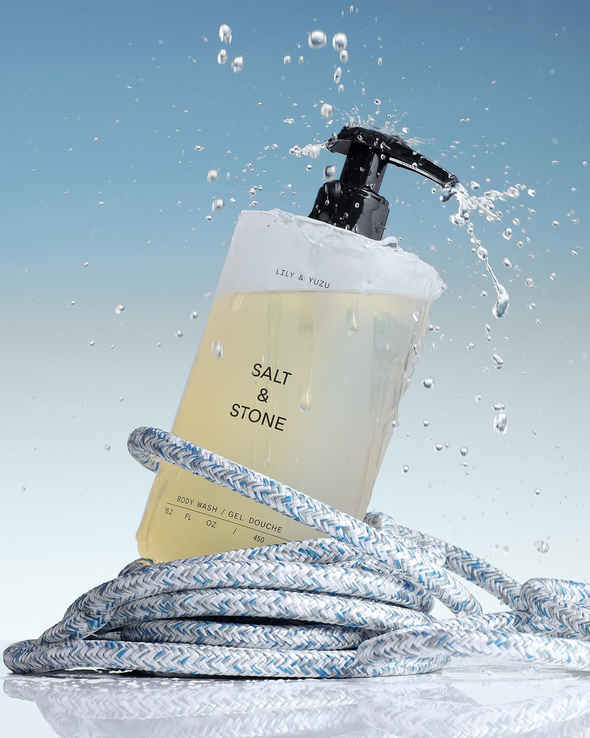 SALT & STONE body wash product photo: pale lemon, black pump and frosted clear, plastic and fabric, bright light