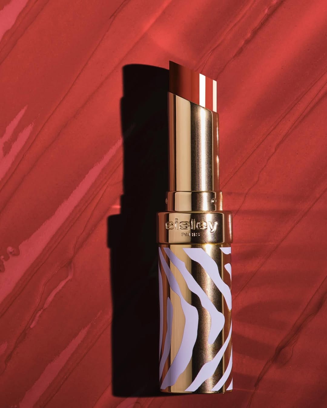 Sisley Paris lipstick product photo: gold, poppy red, chocolate brown and rosewood, metal, soft light, image 3 of 6