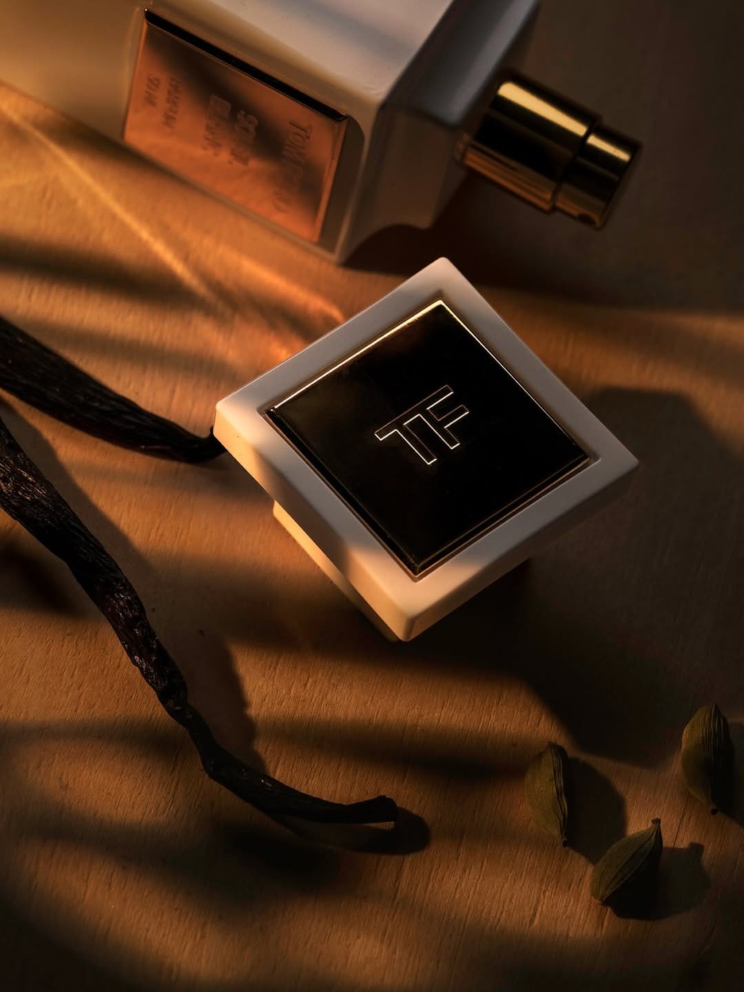 Tom Ford fragrance photography product photo: ivory white, brushed gold and espresso, glass and organic, dramatic light, image 7 of 9
